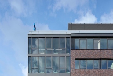 A nyugati, üvegezett fejépület lépcsőszerűen előre tolja mindkét emeletet. A nagyfelületű üvegszerkezetek az épület belső tereinek átlátszóságát biztosítják. - Philips székház, Hamburg - építész: Schaub & Partner Architekten - fotó: Hörmann