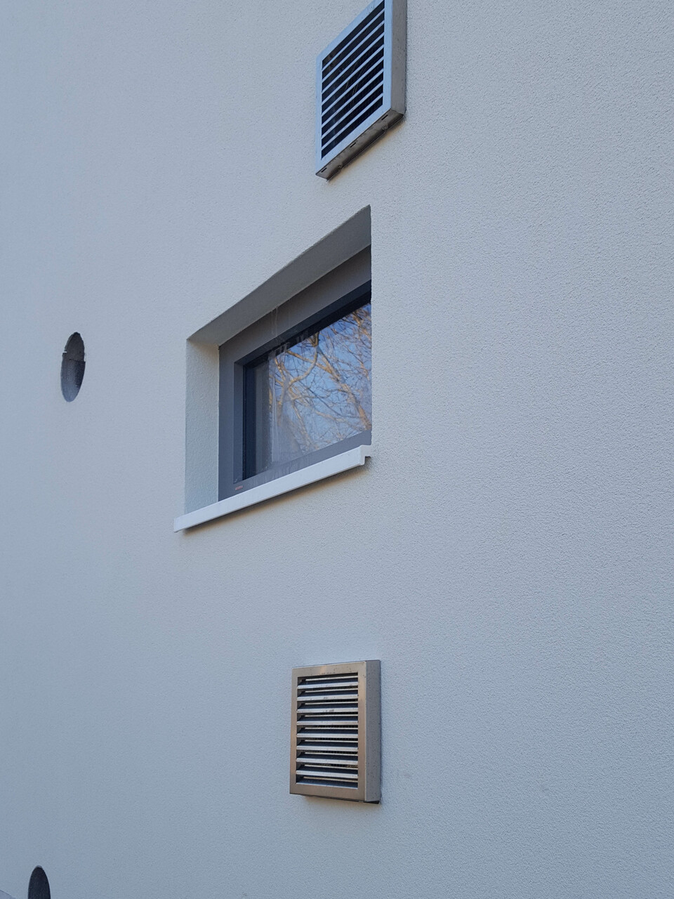 Külső szellőzők megjelenése a falon. A bal oldalon a hőszivattyús bojler, a jobb oldalon a hővisszanyerős szellőzés  csövei láthatók (fotó: Szekér László)