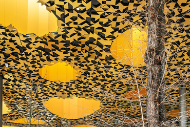 Az épület fás környezetben való elhelyezkedésére utal az álmennyezet arany színű, stilizált levelekből álló díszítése.