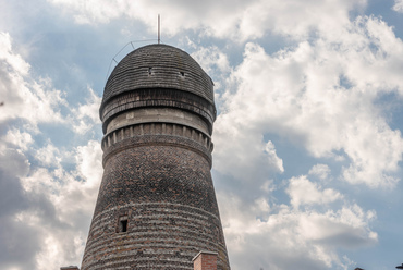 A szép, váltakozó kő és tégla falazatú torony elsőre egykori szélmalomnak tűnik, és ebben az esetben ez igaz is. Az 1841-ben épített gépezet a szeles hegytetőn még harminc évig állta a versenyt a korabeli gőzmalmokkal szemben.