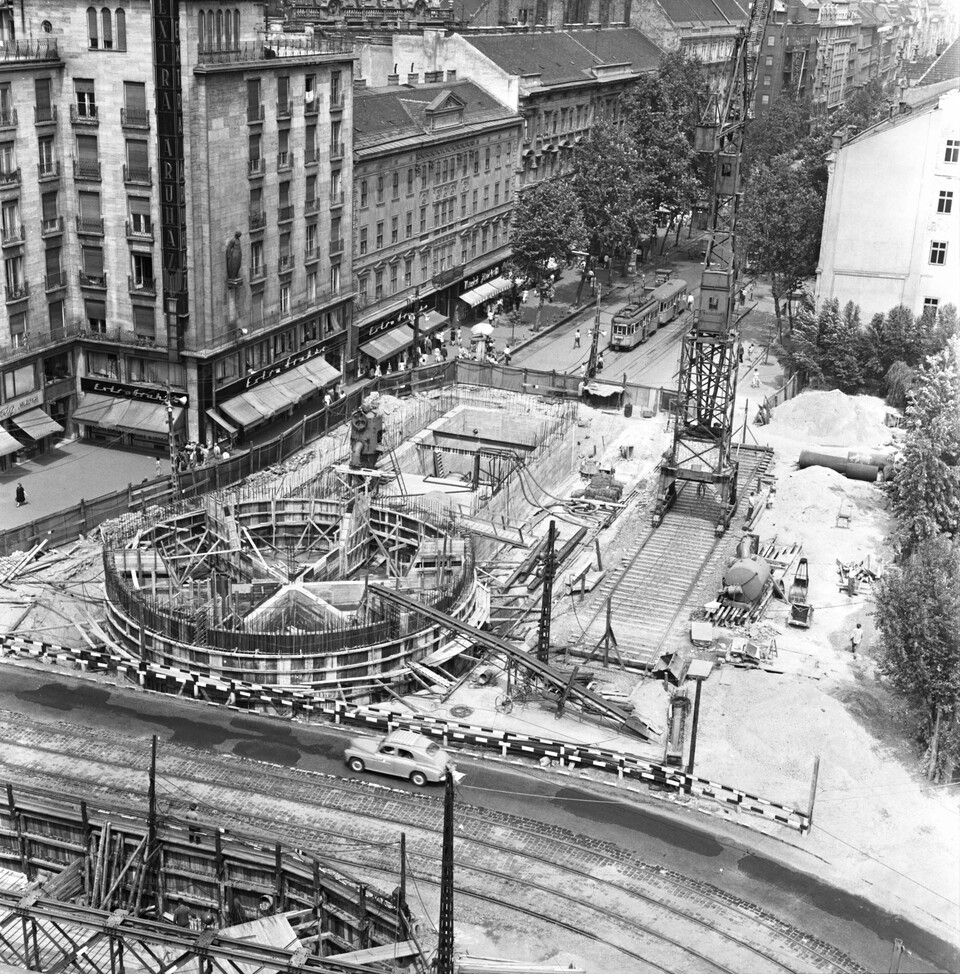 Astoria kereszteződés a Rákóczi út felé nézve, metrólejáró és aluljáró építés. Balra az MTA lakóház, az alsó sarokban az aluljáró építésénél felhasznált Zagyva híd, 1963. Forrás: Fortepan / Főmterv
