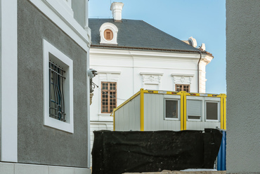 A Szentháromság-tér másik két emblematikus épülete, a nagypréposti, és érseki paloták, egyelőre paravánok mögött állnak, előterük munkaterület, homlokzataik azonban már elkészültek.
