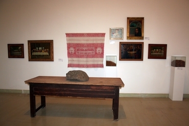 Látványtári installáció faasztallal, mögötte falvédővel