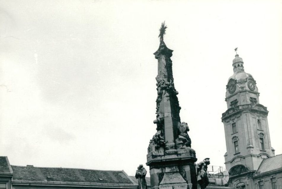 A pécsi Szentháromság szobor a Széchenyi téren, háttérben a városháza tornyával (fotó: FTV / Lechner Fotótár)