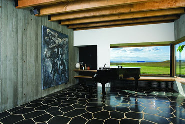 Tipikus izlandi, brutalista stílusú ház: konkrétan és élesen látszanak az anyagok, a beton, a kő, a fa. 