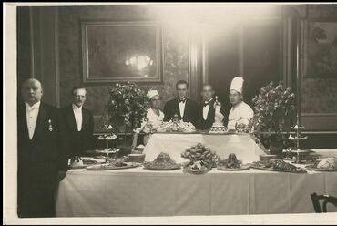 Teríték a budapesti Tiszti Kaszinóban 1930 körül. A megterített asztalok mellett a személyzet tagjai láthatók a vendégekkel együtt. Kép: Magyar Kereskedelmi és Vendéglátóipari Múzeum, via MaNDA