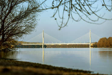 A Duna-part elkerített csápos kútjai, és a sűrű galériaerdők miatt magas vízállásnál csak távolról látható egészében a híd.
