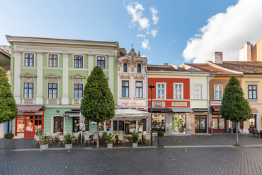 A városfal külső oldala körül egykor hosszan sorakoztak a városi kereskedők bódéi, majd a 18. századtól már a helyükre épült, különböző szélességű lakóházaik sora. Legkeskenyebb képviselőjük a Várkerület  86 alatti, földszintjén a Hoffer Cukrászdával.