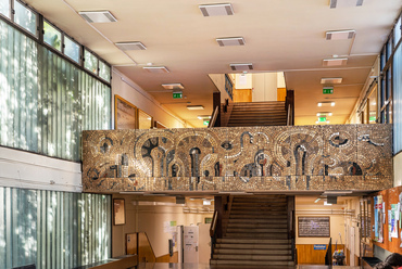 A két épületszárnyat összekötő előtér profilüveg falaival és mozaikjaival szintén az egyetem egyik reprezentatív tere.