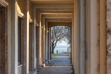 A fűúti járdára szánt árkádsor egyedi összképet alkot a parkerdős, panorámás dombtetővel.
