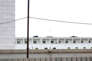“L” beépítésű szociális lakóház Giudecca szigetén, épült Alvaro Siza tervei alapján, 1985-ben. Az épület belső udvara jelenleg átalakítás alatt áll, a szigorúan sorakozó ablakok így az ideiglenes felhúzott építési fal bordázott csíkjaival kerülnek párbeszédbe.
