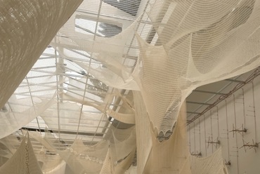 A szerb pavilon belterét egy 10-12 méteres pókhálószerű textilstruktúra szövi be. Textiltervezők, építészek és mérnökök dolgoztak közösen a projekten. A pavilon központi kérdésfelvetése az emberi és gépi munka viszonyát vizsgálja (illeszkedve a Biennálé tágabb kurátori koncepciójához). A látványos vajszínű anyagot hónapokon keresztül szőtték Szerbiában, majd lebontották hengerekbe helyezték a fonalakat és egy újabb hónap alatt ismét felszőtték, már a velencei kiállítótérben. A kiállítótér falaira napelemmel működő mechnaikus rokkákat szereltek fel, amelyek meghatározott sebességben, fokozatoasan bontják le a nagy textiltrendszert, amely a Biennálé utolsó napjára teljesen el fog tűnni. Az emberi munka technológiai dekonstrukciójának modellje a pavilon, amely állandó mozgásban van, mégis alig észrevehetően változik napról napra. 
