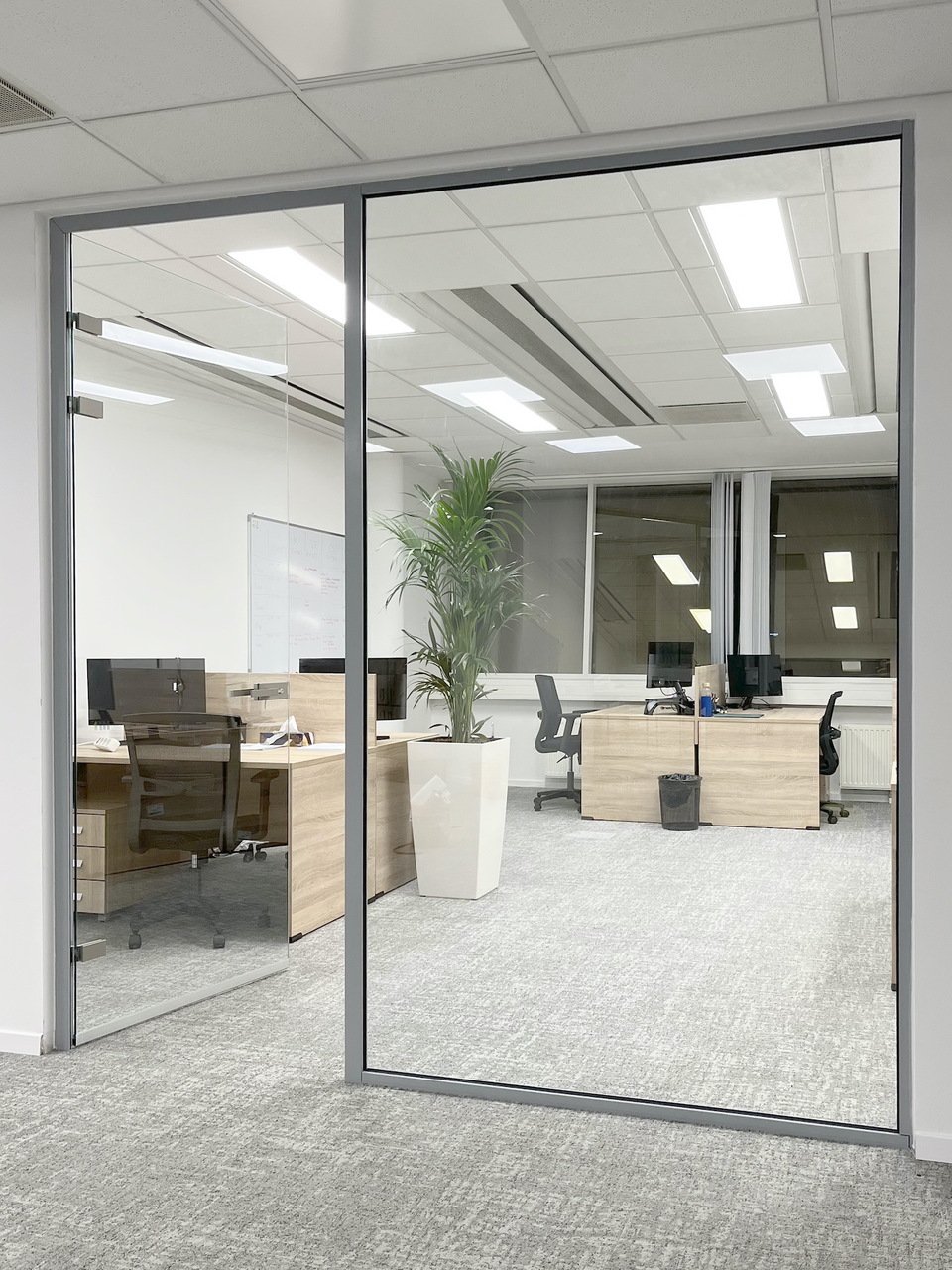 Dual-Office irodai üvegfal szálcsiszolt profilos, keret nélküli üvegajtóval, három zsanérral. Forrás: Dual Glass