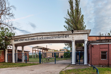 A sziget középső részét két óriási telek uralja. Az Újpesti-öbölre néző egykori gyár pompás kapuja mögött mára teljesen elhagyott és kifosztott csarnokok állnak.
