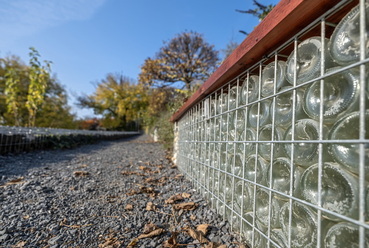 Kortárs megoldás a pezsgősüvegek alkalmazása. Támfalak, padok testét adják, utalva a borászat jelenlétére.  // Szent Erzsébet emlékpark, Balatonboglár
